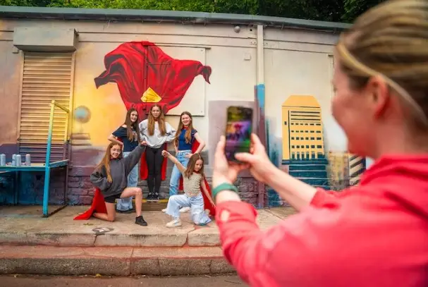 Fresque murale Superman à Manchester avec passants prenant la pose