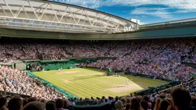 Vue aérienne du Centre Court de Wimbledon baigné par la lumière, symbole de légende et de tradition