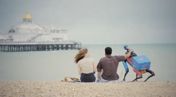 Domidog, le robot livreur de pizzas de Domino’s, sur une plage britannique en pleine mission