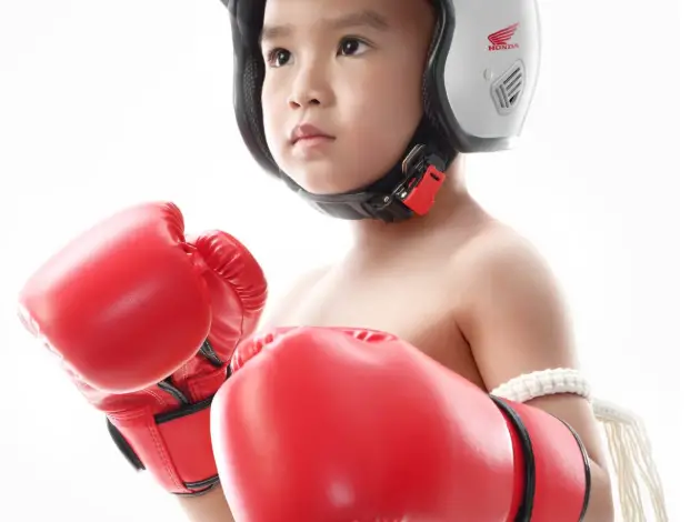 Affiche de la campagne Honda en Thaïlande montrant un enfant vêtu comme un pilote avec un casque sur la tête — campagne de prévention routière