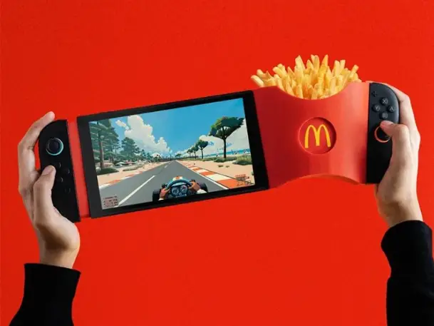 Un gamer tenant une Nintendo Switch 2 avec un support GamiFries fixé – Support GamiFries imprimé en 3D fixé sur la Nintendo Switch 2 avec une boîte de frites McDonald’s.