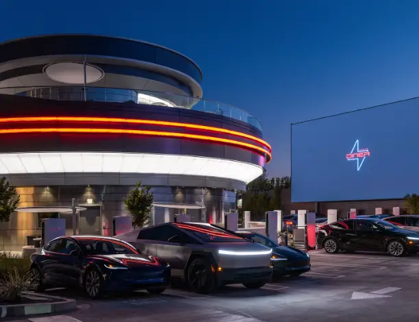 Façade du Tesla Diner à Hollywood de nuit avec lumières néon et voitures électriques garées