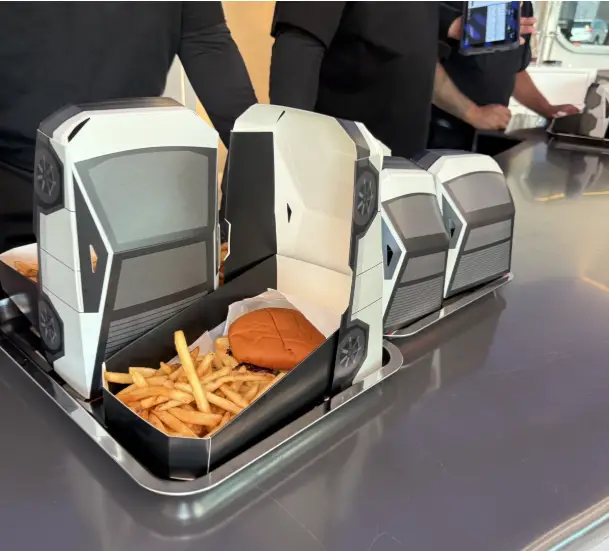 Menu Tesla avec burger servi dans une boîte en forme de Cybertruck